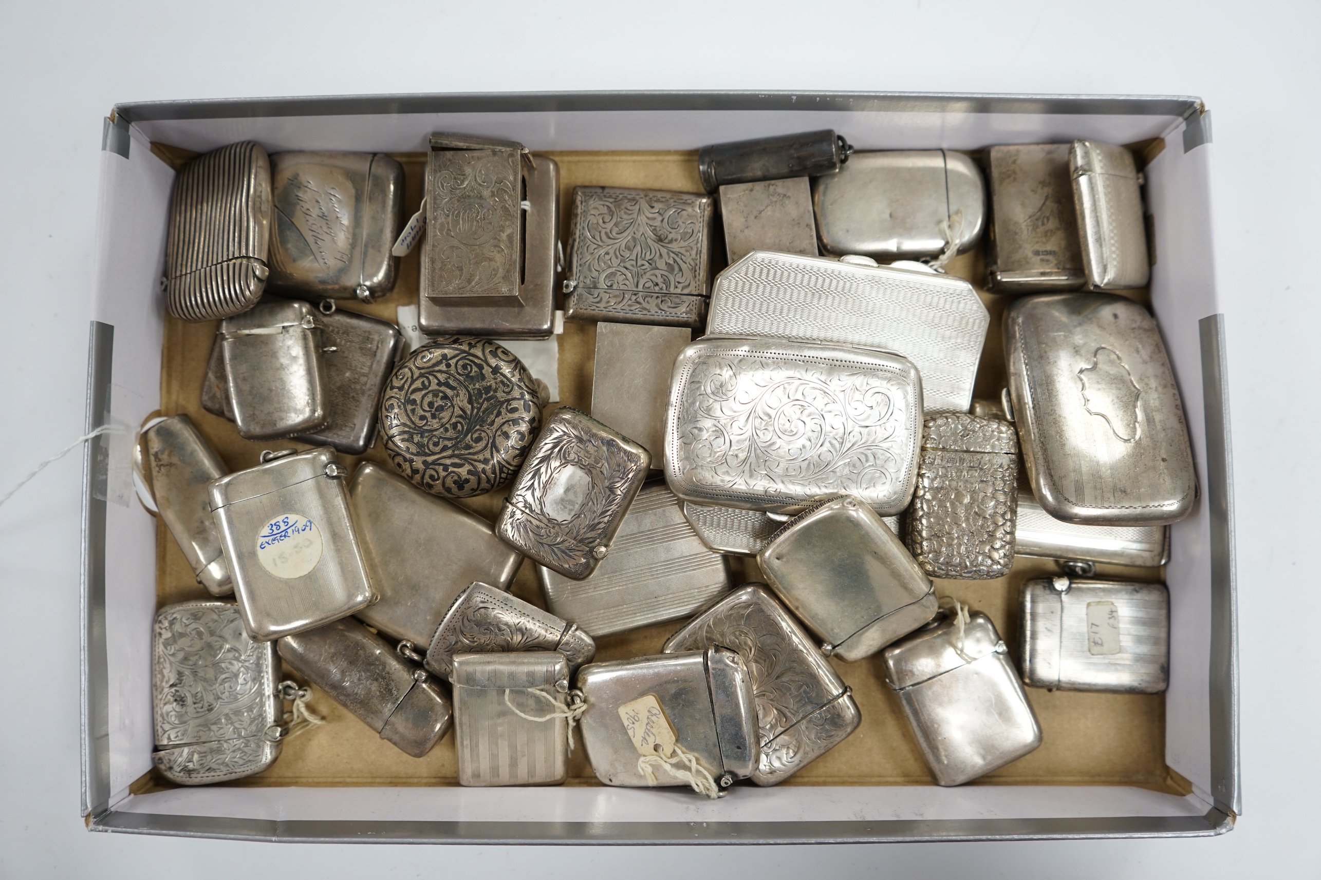 A collection of twenty four assorted silver vesta cases, eight cigarette cases, two match sleeves and a late 19th century Russian 84 zolotnik niello small tobacco box. Condition - poor to fair